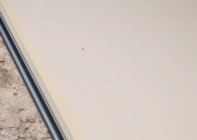 Chez-Camille-et-Arthur-4 Een zilverkleurige metalen rand scheidt een beige stenen vloer van een gladde en heldere oppervlakte.